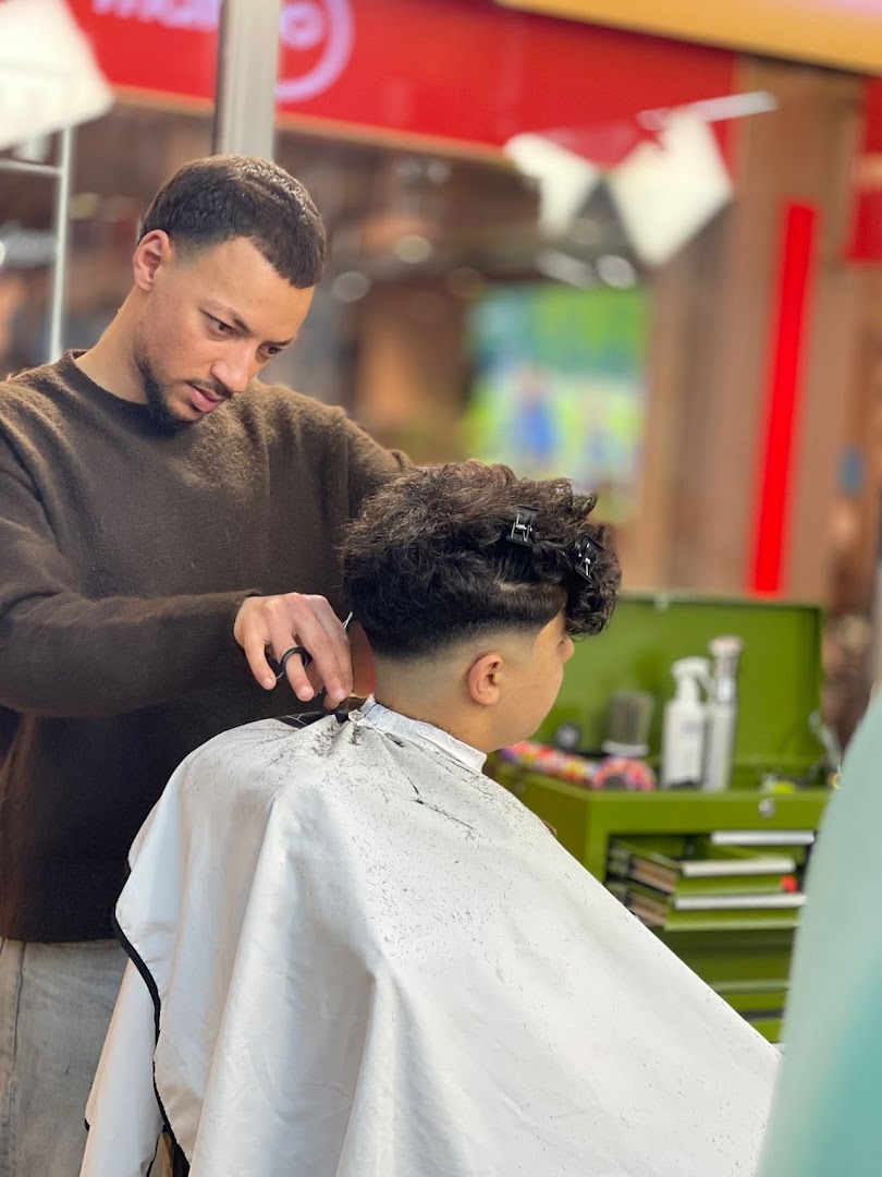 Hakim knipt een klant in Hakim's Blade&Fade, close-up van een lopende knipbeurt